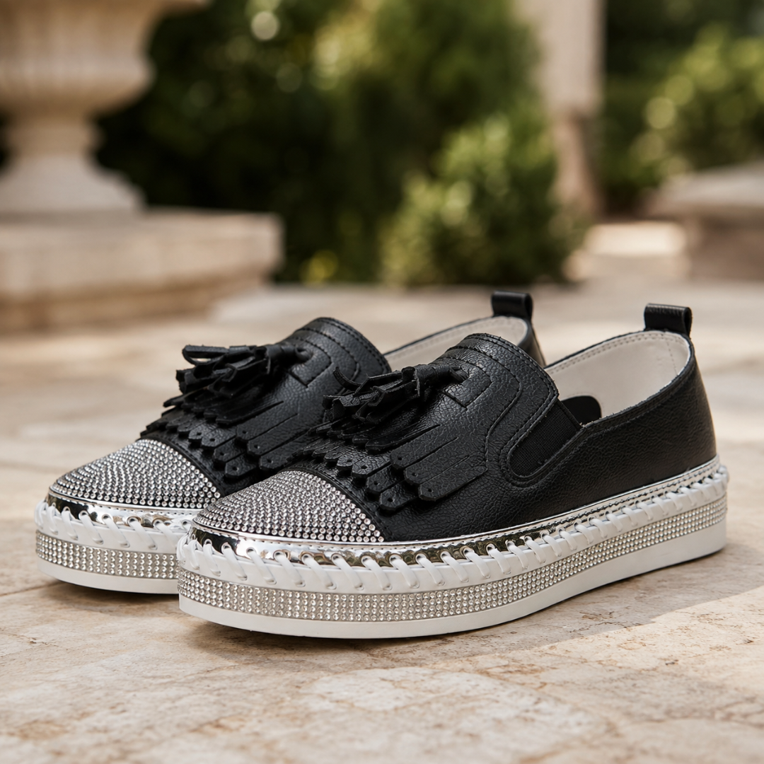 Sneakers nere di fronte con nappine, profilo metallico e suola platform bianca intrecciata