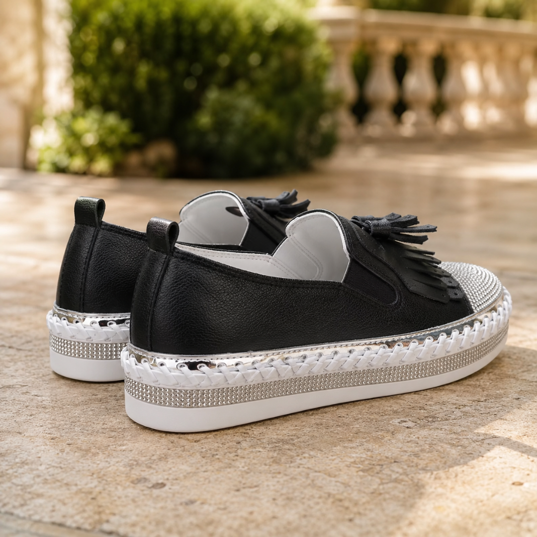 Vista posteriore delle sneakers nere con linguetta e suola platform bianca con strass