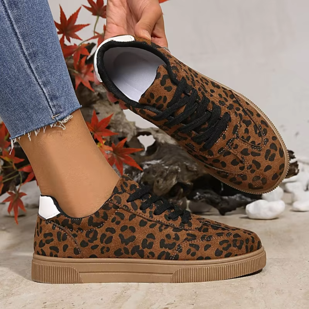 Sneakers donna a stampa leopardata tenute in mano, interno bianco e suola rigata