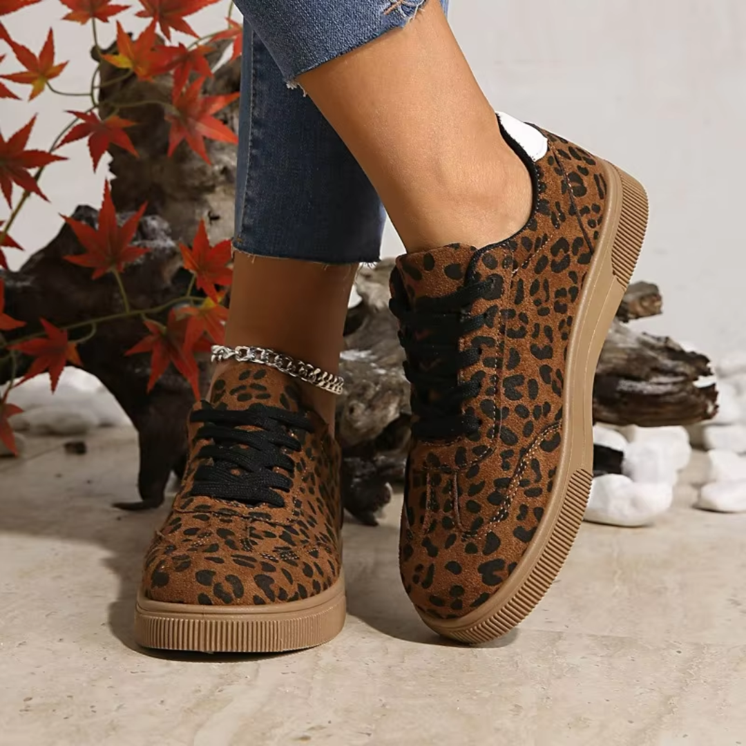 Sneakers basse leopardate con punta tonda e lacci neri, vista laterale ai piedi