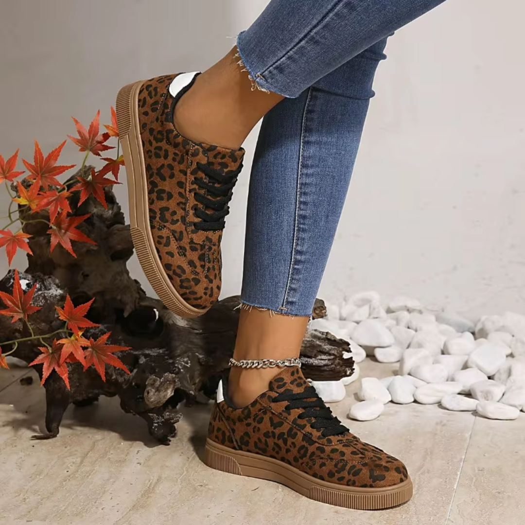 Sneakers donna leopardate abbinate a pantaloni chiari, lacci neri in primo piano