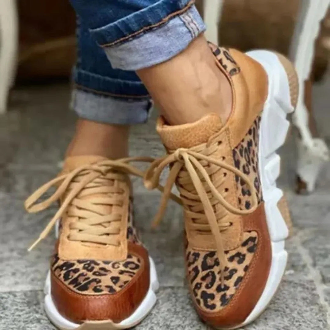 Dettaglio ravvicinato delle sneakers cammello leopardate con occhielli e lacci annodati