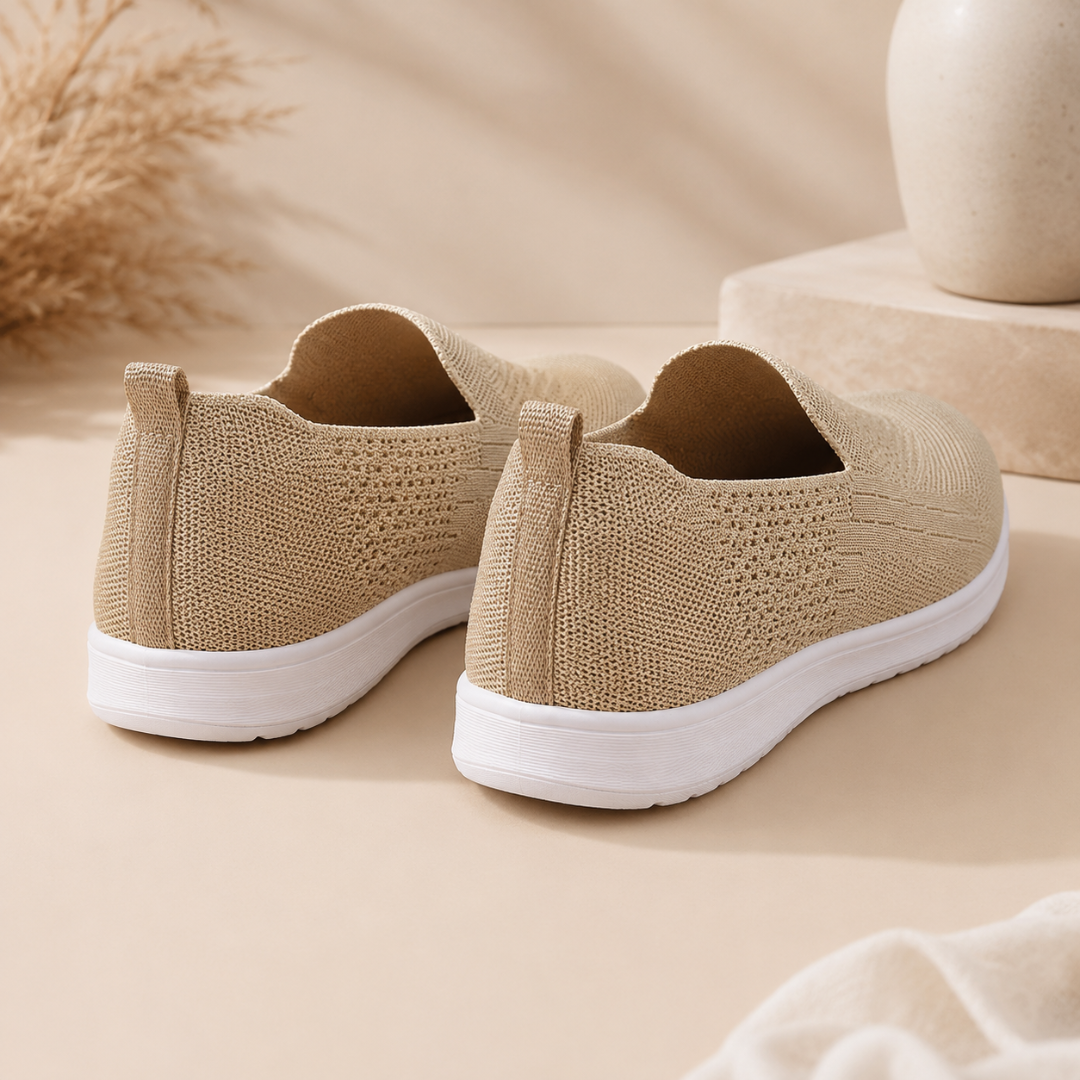 Vista posteriore delle sneakers beige in maglia con linguetta al tallone e suola bianca