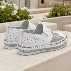 Vista posteriore delle sneakers bianche con perforazioni a stella e linguetta al tallone
