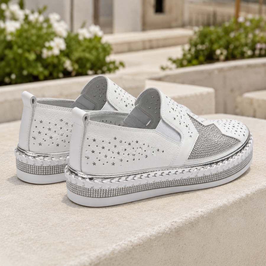 Vista posteriore delle sneakers bianche con perforazioni a stella e linguetta al tallone