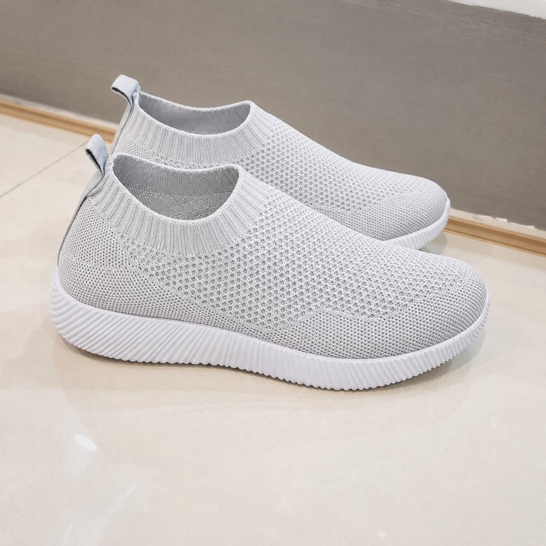 Sneakers donna slip on grigio chiaro traforate con suola bianca rigata, vista laterale