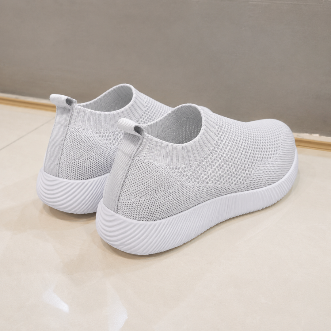 Retro delle sneakers grigio chiaro con linguetta posteriore e bordo a coste