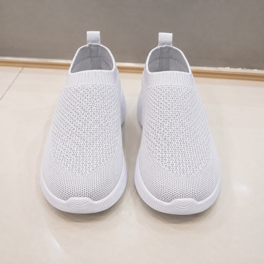 Vista frontale delle sneakers grigio chiaro con tomaia traforata e punta tonda