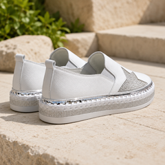Vista posteriore delle sneakers bianche con linguetta e bordo intrecciato sulla suola
