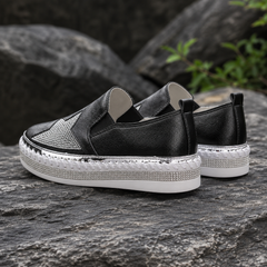 Vista posteriore delle sneakers nere con linguetta e bordo intrecciato bianco