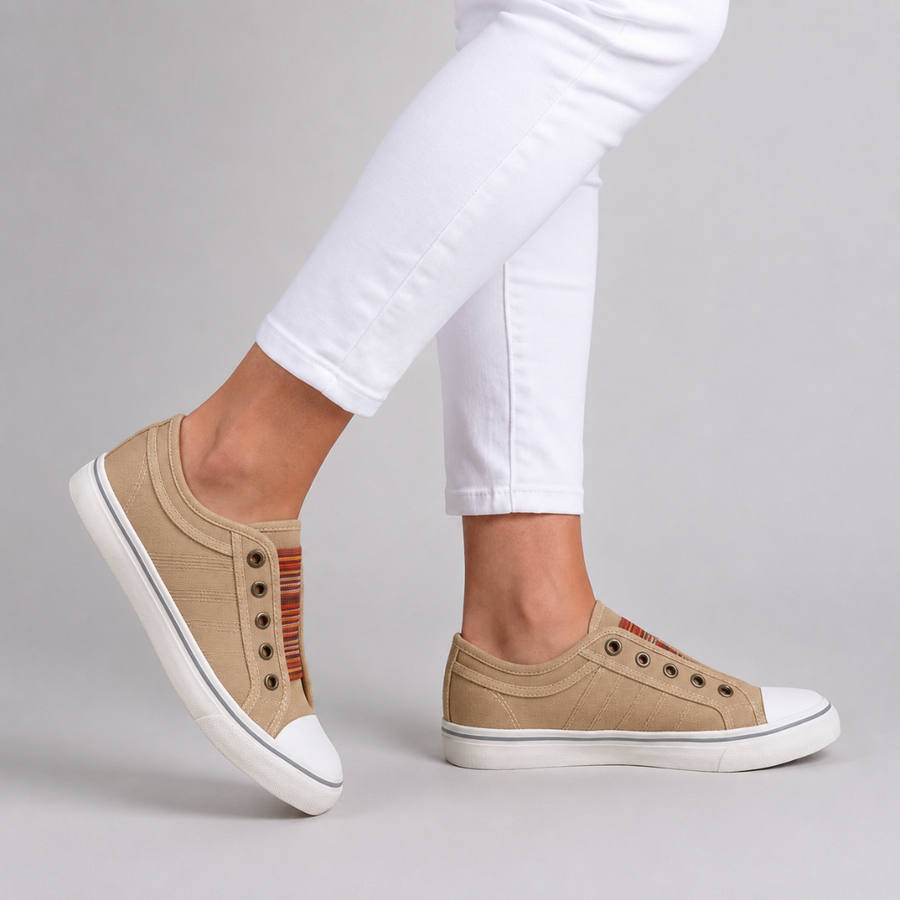 Sneakers beige senza lacci viste di lato con occhielli brunati e fondo bianco flessibile