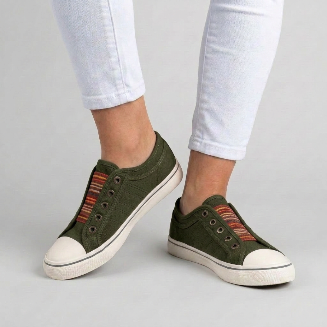 Sneakers verde militare senza lacci indossate con pantaloni bianchi e punta bianca arrotondata