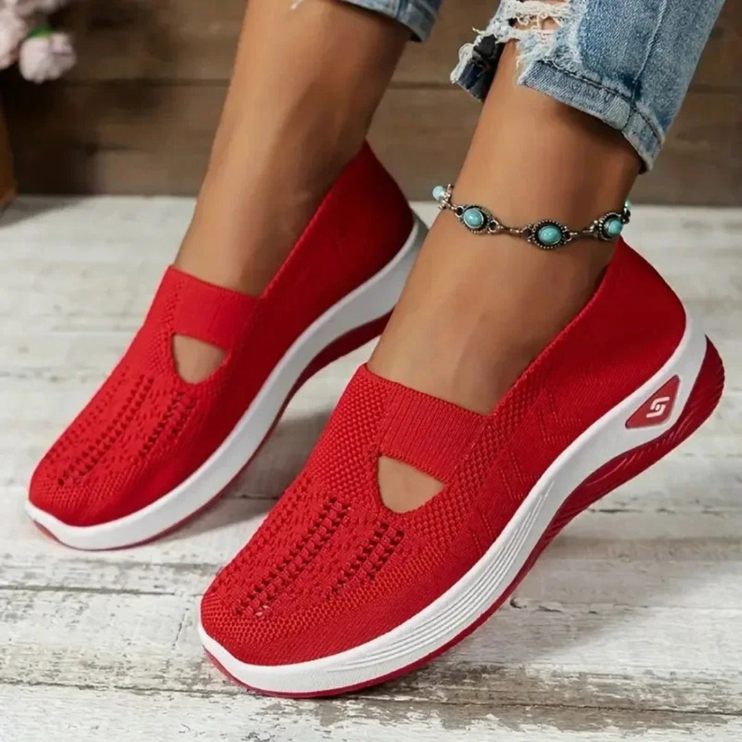 Sneakers rosse donna traforate indossate, profilo della suola bianco a contrasto