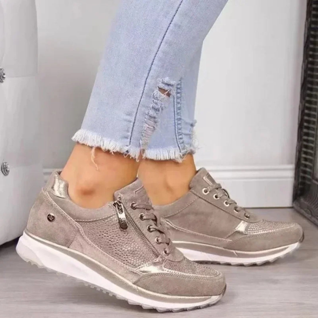 Sneakers beige di profilo con zip laterale dorata e spessa suola bianca