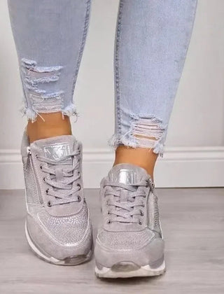 Sneakers donna grigie indossate con pantaloni chiari, strass sulla punta e lacci larghi