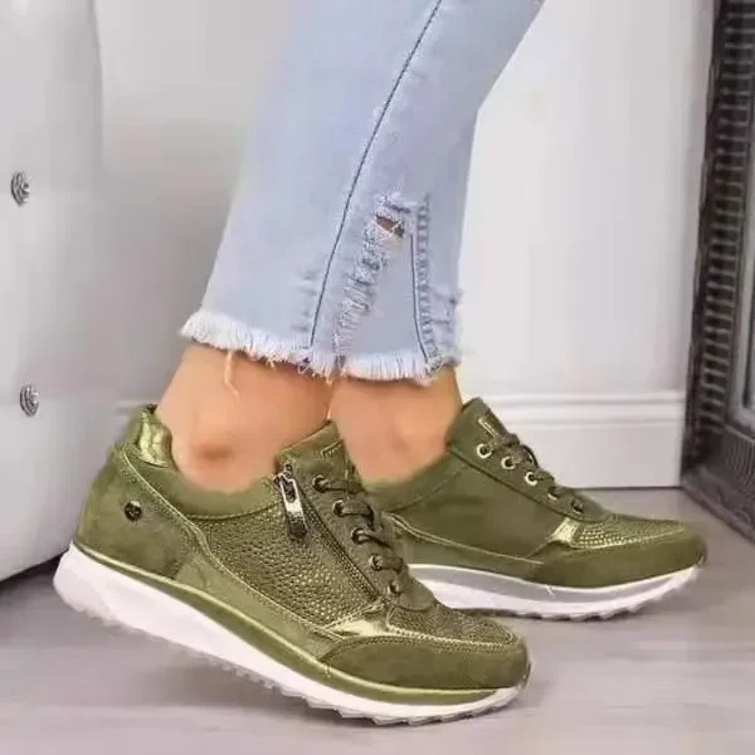 Sneakers verdi di profilo con zip metallica e suola alta bianca a zeppa