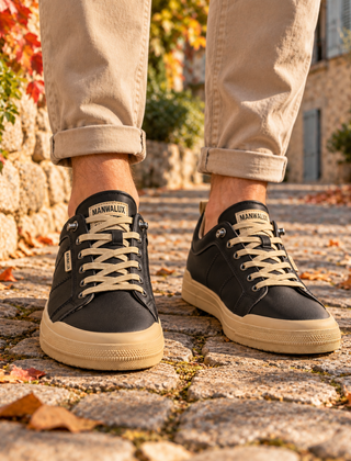 Sneakers uomo nere con suola a contrasto e lacci chiari, indossate su pavé