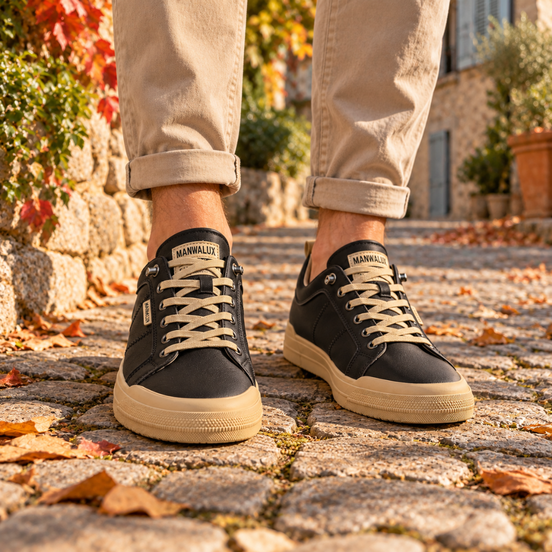 Sneakers uomo nere con suola a contrasto e lacci chiari, indossate su pavé
