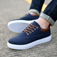 Sneakers blu navy da uomo indossate con pantaloni scuri, suola bianca visibile