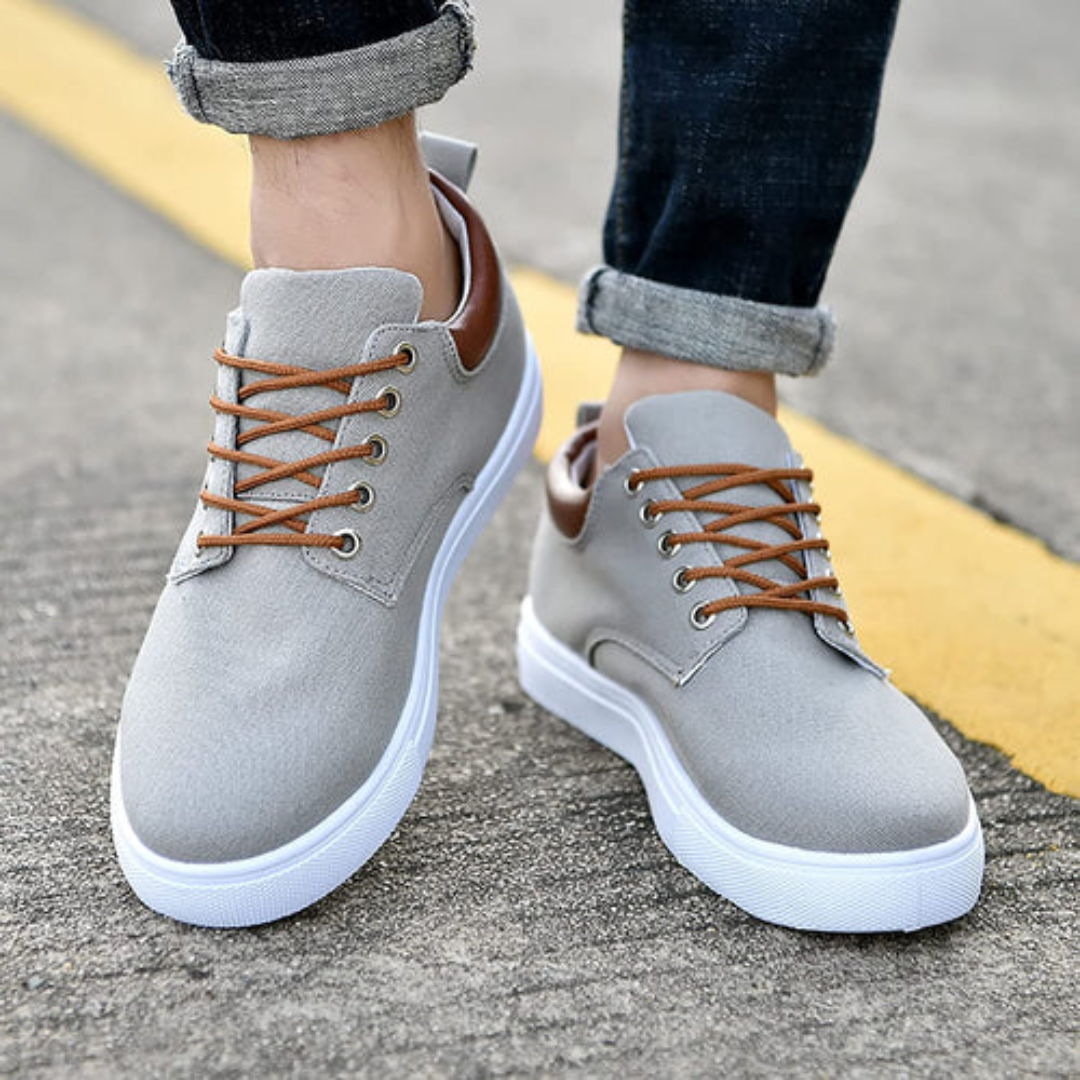 Paio di sneakers uomo grigie viste dall'alto con allacciatura incrociata a contrasto