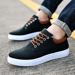 Sneakers nere da uomo indossate con pantaloni risvoltati, tallone lucido marrone