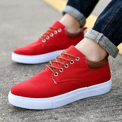 Sneakers rosse da uomo indossate con pantaloni scuri risvoltati, occhielli argentati