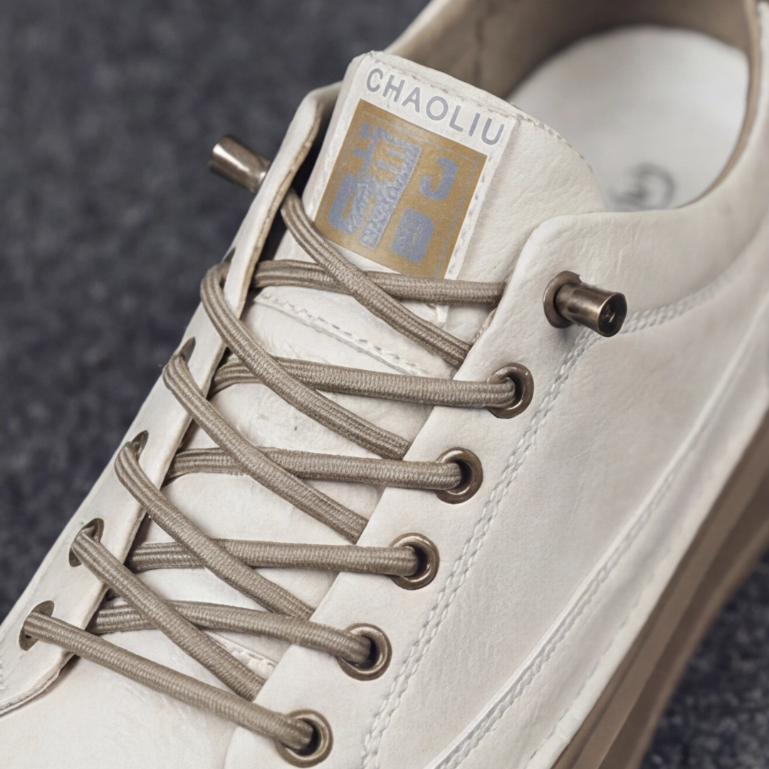 Dettaglio sneakers uomo beige con lacci tondi, occhielli metallici ed etichetta sulla linguetta