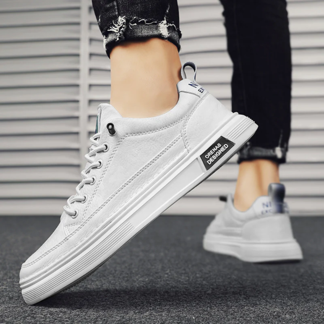 Sneakers uomo bianche basse indossate, placca laterale nera e suola scanalata