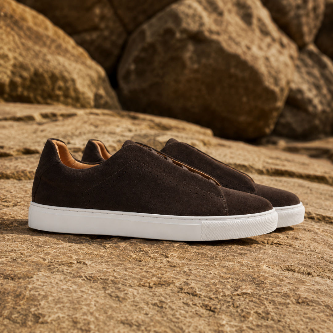 Sneakers uomo marrone scuro viste di lato con fori decorativi lungo il fianco