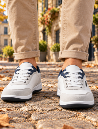 Sneakers uomo bianche viste di fronte con tallone blu e lacci bianchi