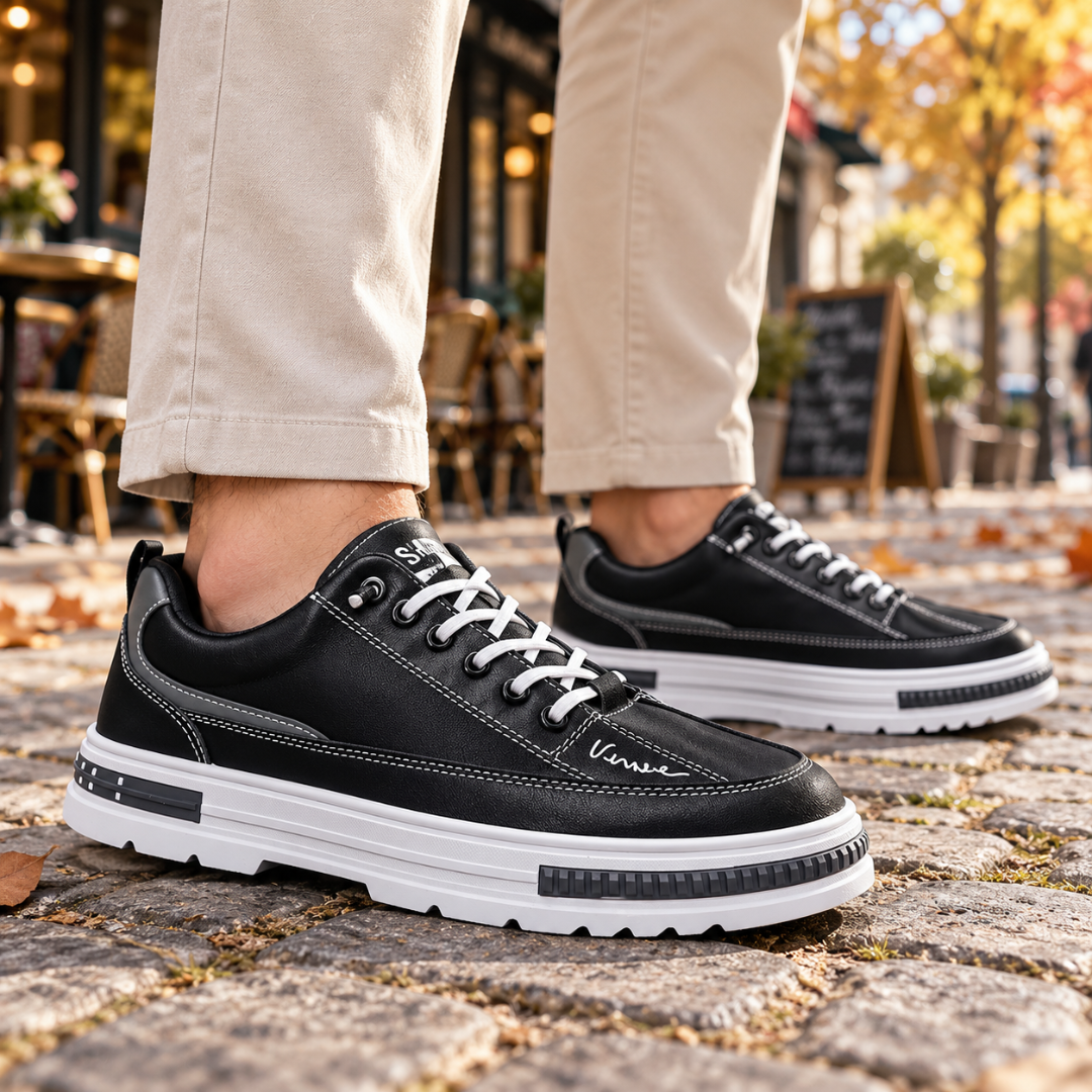 Sneakers uomo nere in primo piano con lacci bianchi e bordo suola dentellato