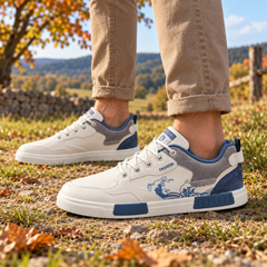 Sneakers bianche da uomo con inserti grigi e blu su prato autunnale