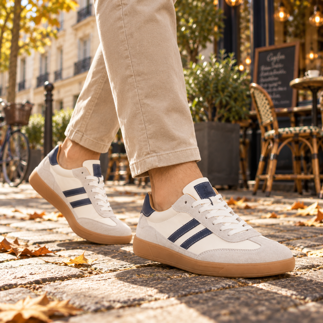 Sneakers basse bianche in movimento, bande blu e lacci bianchi in vista