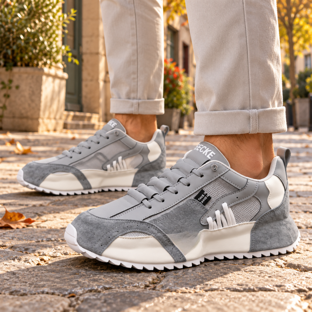 Sneakers uomo grigie con inserti bianchi, rete laterale e suola dentellata bianca