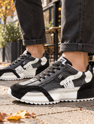 Sneakers uomo nere con inserti bianchi a contrasto e suola dentellata bianca