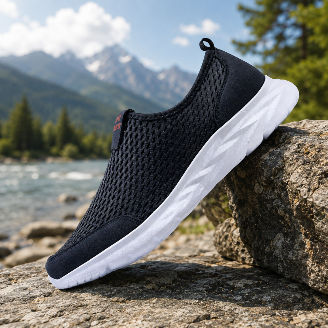 Sneakers uomo slip-on blu traforate con suola bianca appoggiate su roccia