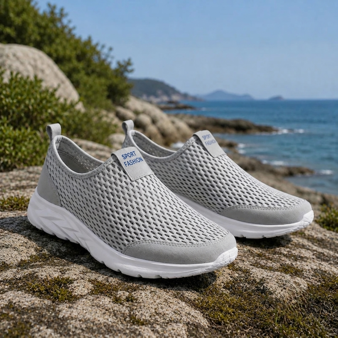 Sneakers uomo slip-on grigie con tomaia traforata e suola bianca su roccia