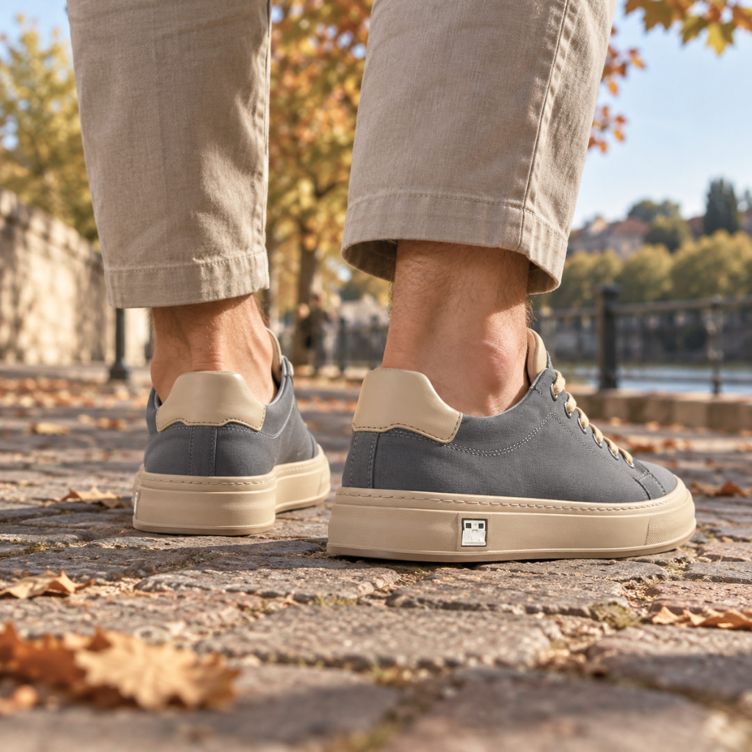 Retro delle sneakers grigie con inserto chiaro sul tallone e suola a contrasto