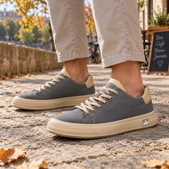 Sneakers uomo grigie con punta tonda e allacciatura chiara, abbinate a pantaloni beige