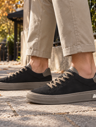 Sneakers uomo nere con suola tortora a contrasto e lacci chiari su strada