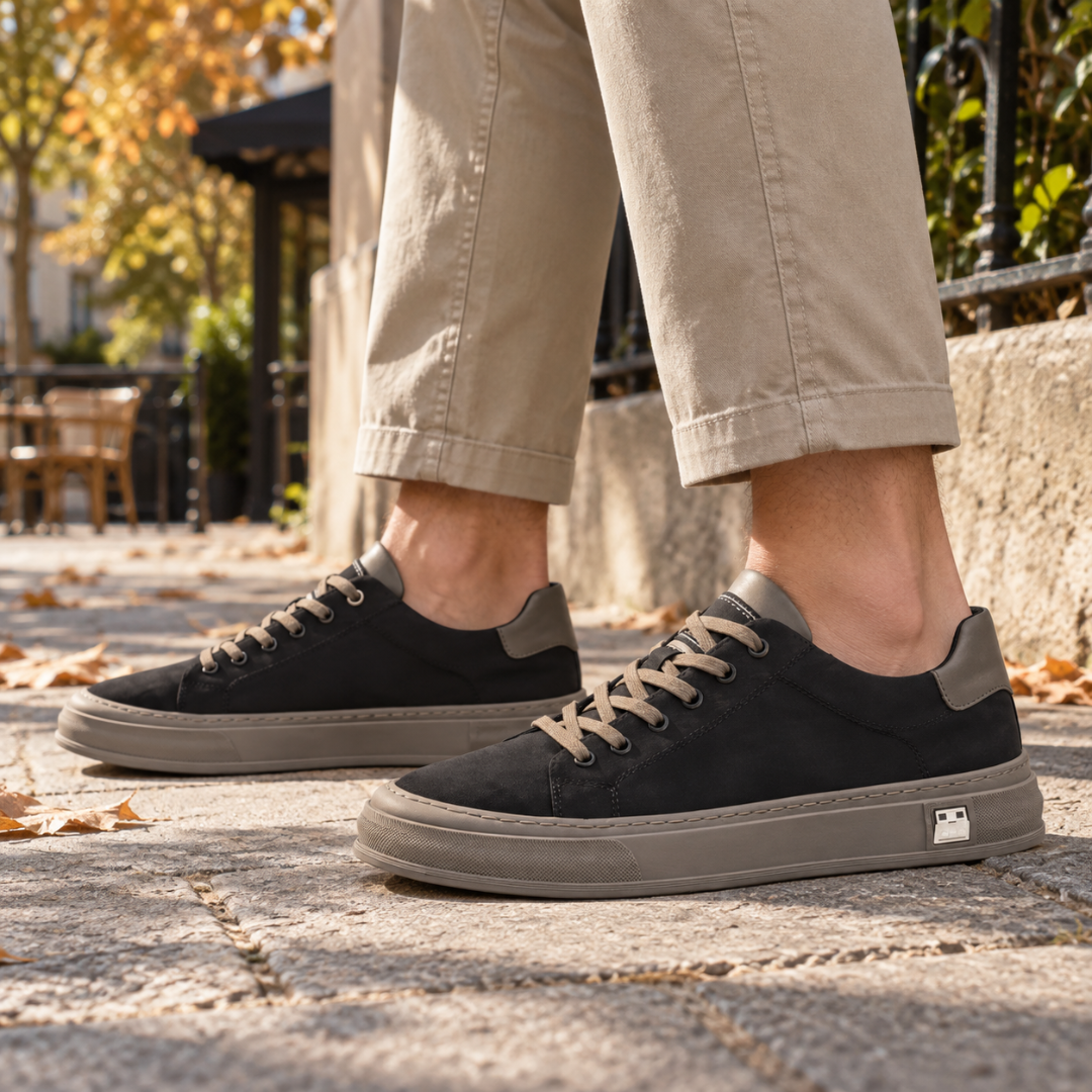 Sneakers uomo nere con suola tortora a contrasto e lacci chiari su strada