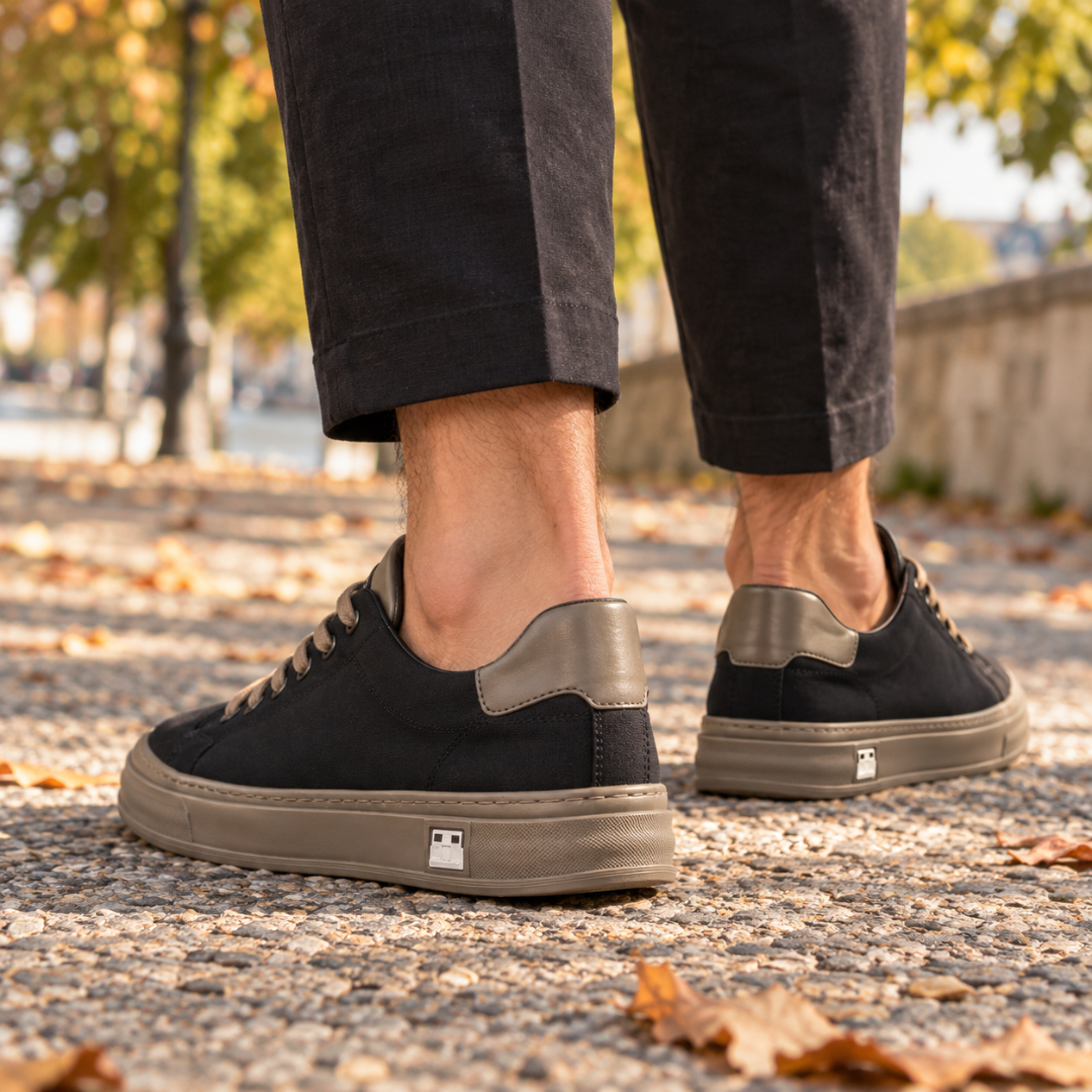 Vista posteriore delle sneakers nere con inserto tortora sul tallone e cucitura visibile