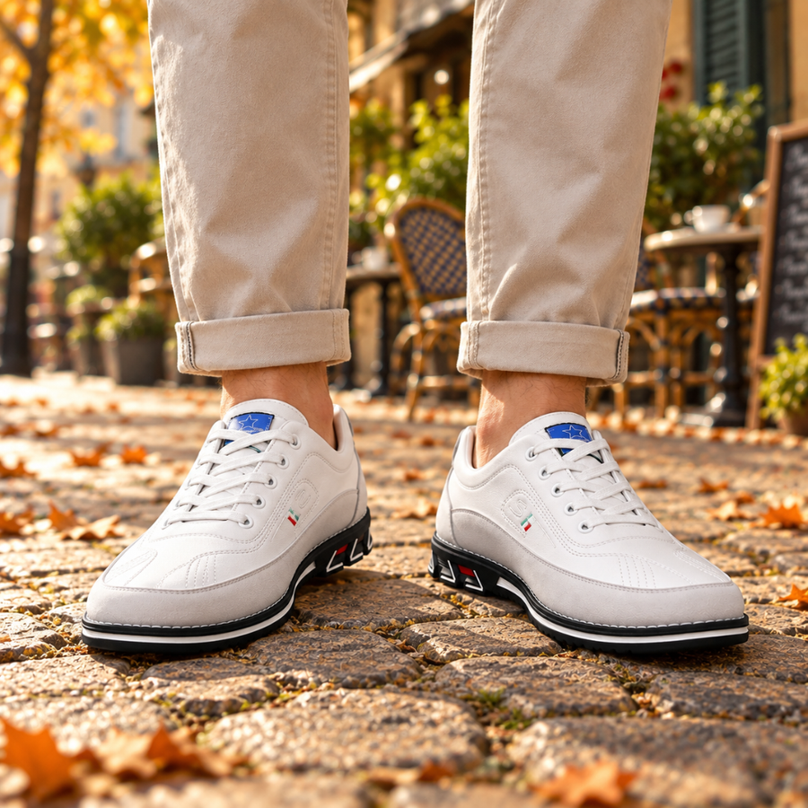 Sneakers uomo bianche basse con lacci, viste frontalmente con suola nera a contrasto