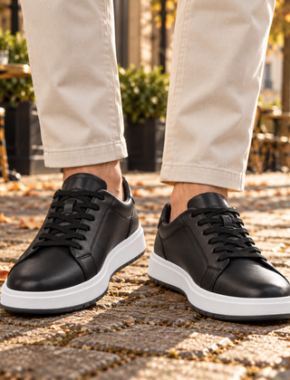Sneakers uomo nere con lacci neri e suola bianca viste frontalmente