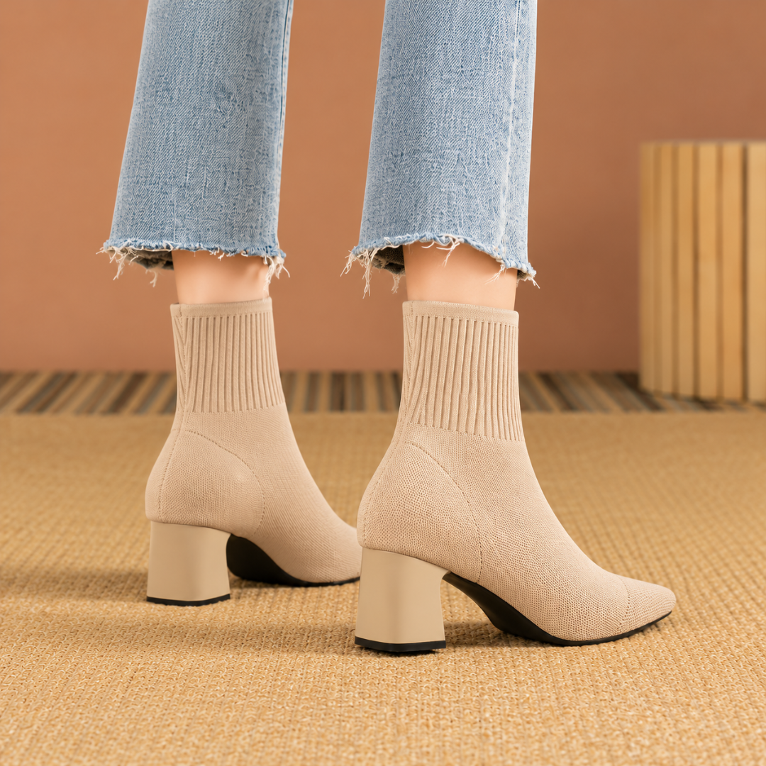 Vista posteriore degli stivaletti beige con tacco largo e suola sottile scura