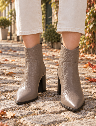 Stivaletti donna kaki a punta con tacco largo, indossati su pavimentazione con foglie autunnali