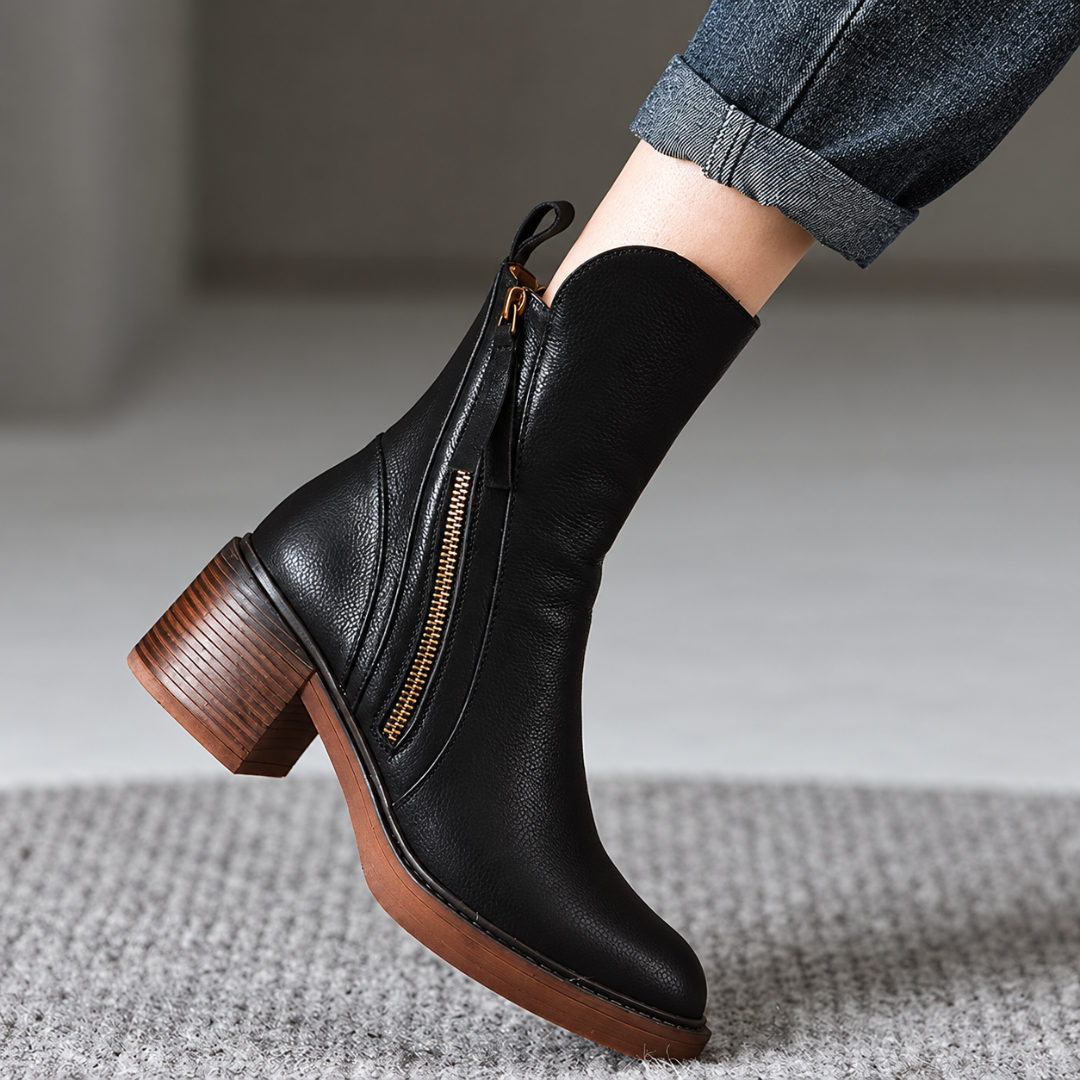 Stivaletto nero indossato con pantaloni risvoltati, zip laterale e punta tonda