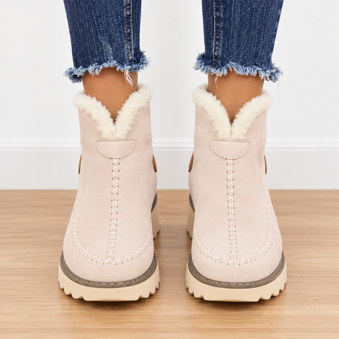 Stivaletti beige visti di fronte con bordo effetto pelliccia e cuciture centrali