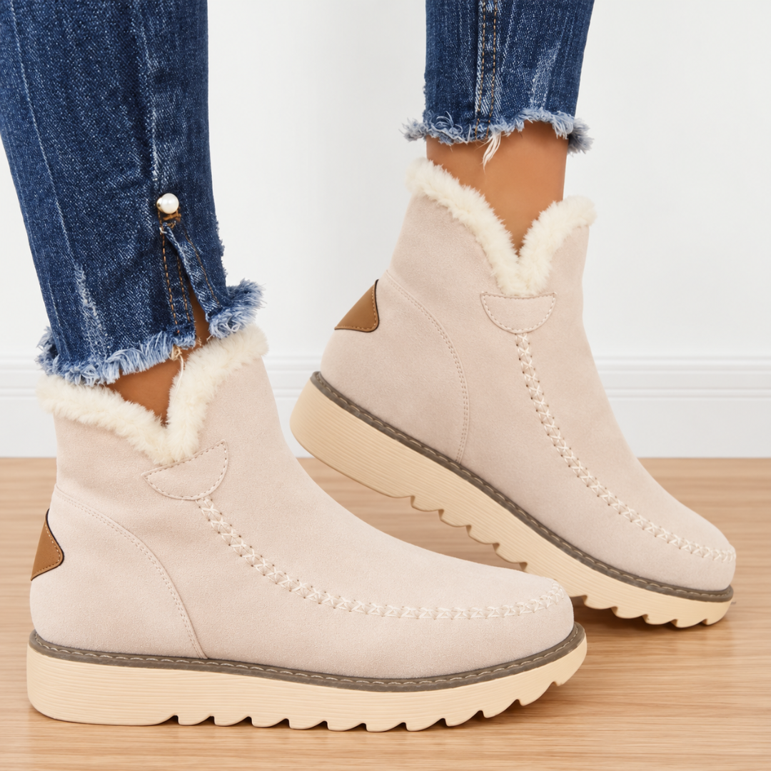 Stivaletti beige indossati con pantaloni sfrangiati, risvolto effetto pelliccia e linguetta