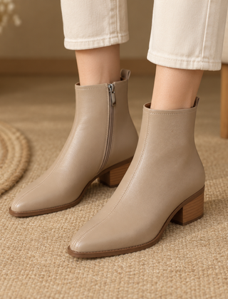 Stivaletti beige alla caviglia con zip laterale e tacco largo, indossati con pantaloni chiari